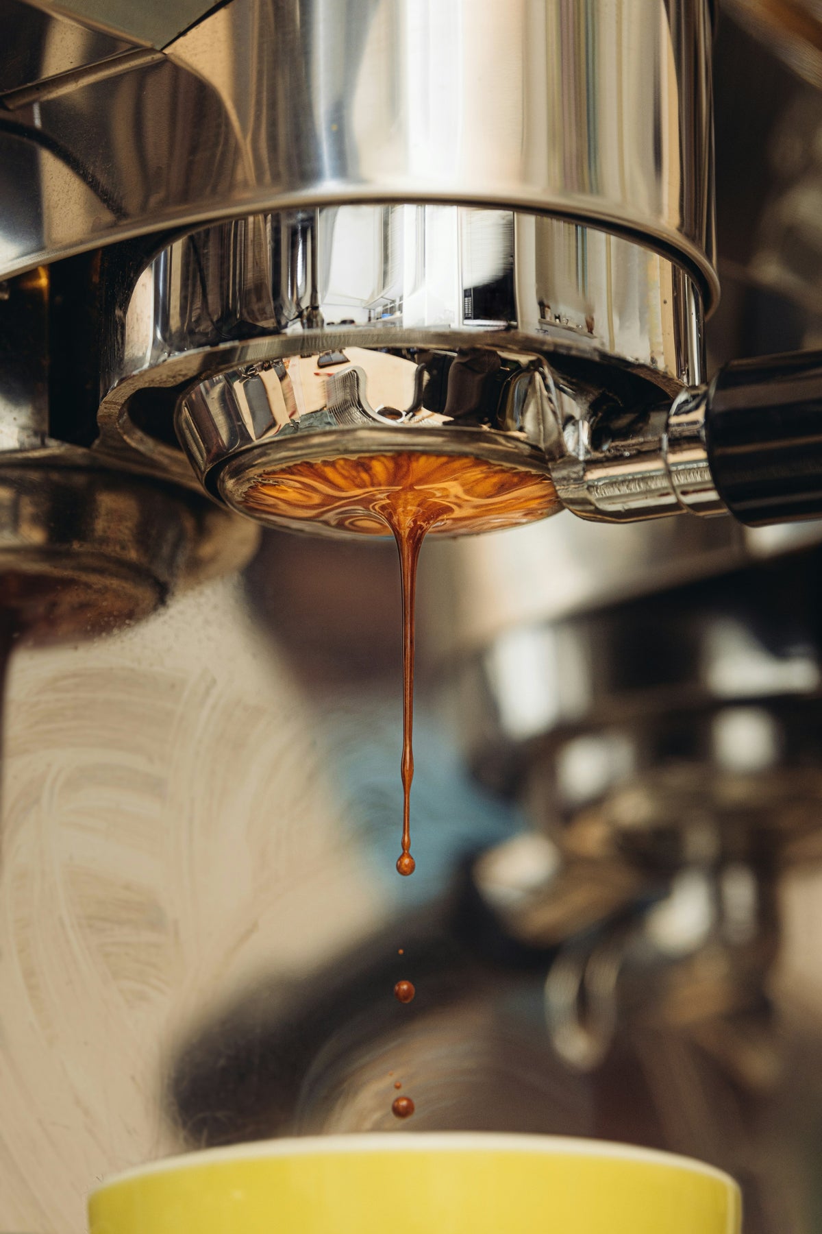 Espresso shot pulling from a portafilter into a cup